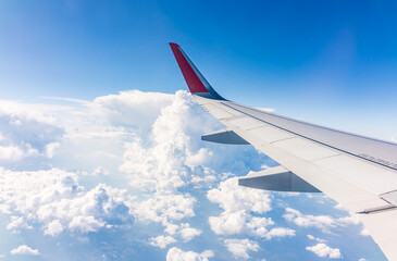 View from the airplane window at a beautiful cloudy sky and the airplane wing