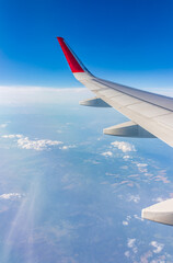View from the airplane window at a beautiful cloudy sky and the airplane wing