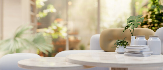 A modern neutral marble coffee table with a blurred background of a beautiful sunny home garden view