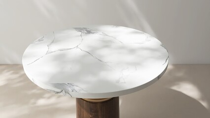 High angle view of round white marble pedestal table podium in dapple sunlight, shadow on white...