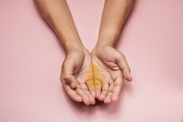 Obraz premium A human hand showing a colored dry leaf on his palm