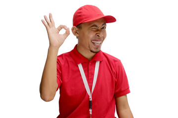 Excited Asian delivery man showing an OK gesture and winking one eye at the camera, indicating...
