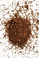 Pile of freshly ground coffee beans on a white background