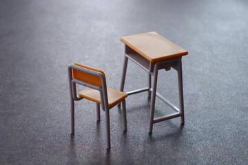 学校の机と椅子が表す、教育に関するさまざまな問題のイメージ