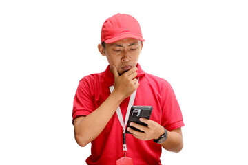 Asian delivery man or courier looking confused and thoughtful, trying to find solutions and solve problems on his smartphone. Isolated on a white background