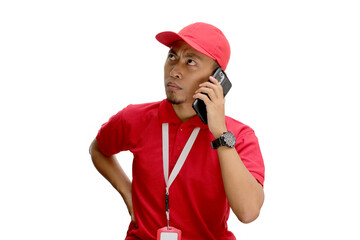 Annoyed Asian delivery man or courier talking on his phone, handling issues such as bad or...