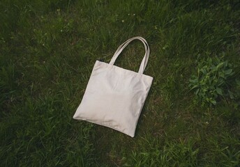 Tote bag on green grass, mockup. Canvas textile natural tote bag mockup, lying on lawn in nature.