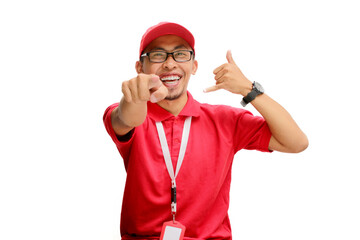 Asian delivery man or courier stands confidently against a white background, pointing directly at...