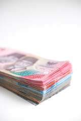 A stack of various Indonesian rupiah banknotes on a white background