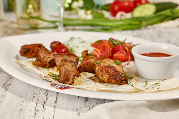 Pork Shashlik with Lavash, Sauce, and Fresh Vegetable Salad in Sunlight on Wooden Table