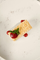 Napoleon Pastry with Berry Sauce on Sunlit Wooden Surface