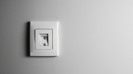 A minimalist scene features a white light switch mounted on a pristine white wall. 