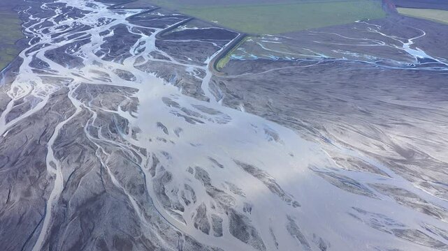 Aerial view of glacier river branches from above, Icelandic glacial river bed and moraine by drone. Climate change and global warming