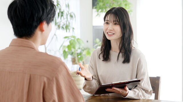 男性にインタビューをする女性