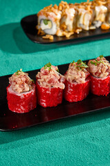 Delicious Crab Roll with Tobiko Roe Presented on Black Plate - Gourmet Sushi Plating for Modern Cuisine