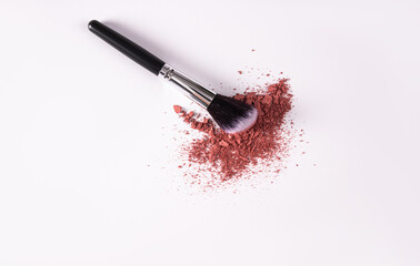 A sample of pink loose blush on a white background with a makeup brush. A copy space. top view. a...