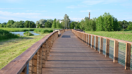 A long wooden boardwalk with a fence on the side. 