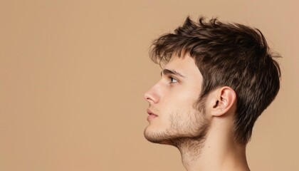 Fototapeta premium Side Profile of Young Man on Warm Beige Background, Copy Space, Banner