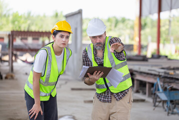 Engineer and foreman worker checking project at building site, Engineer and builders in hardhats discussing on construction site, Teamwork concepts