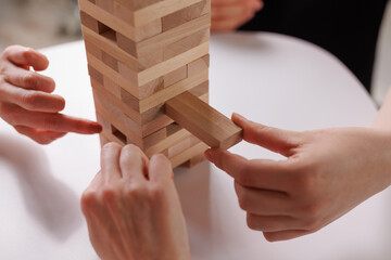 two women playing Jenga board game at home, excitement and relaxation, mind development concept,