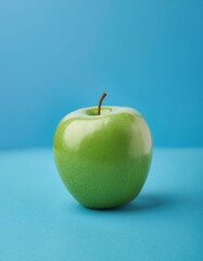 Green apple in blue background, raw fresh and vibrant in minimalistic food photography.
