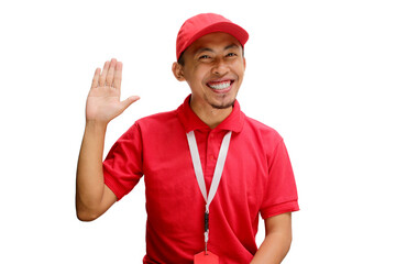Cheerful Asian delivery man or courier smiles warmly, saying hi and waving his hand to greet someone with a hello gesture. Isolated on a white background