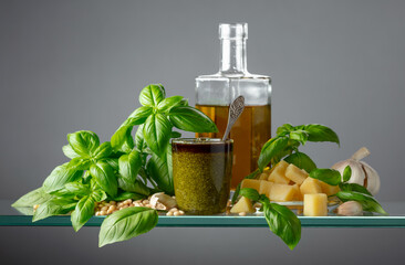 Pesto sauce and ingredients on a glass table.