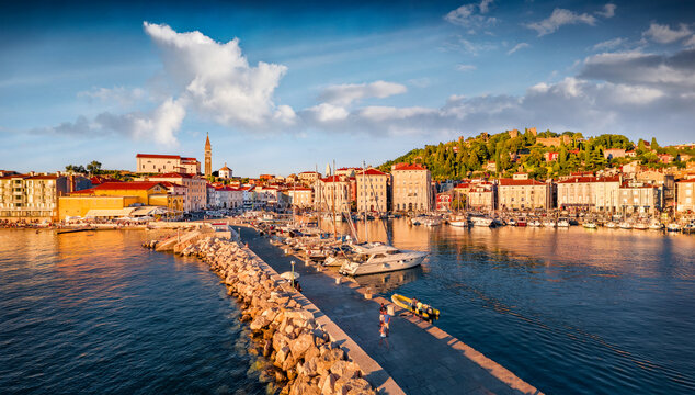 Warm sunlight glowing of Adriatic coast with beautiful Venetian architecture. Stunning morning cityscape of Piran town. Amezing cityscape of old port of Slovenia, Europe. Travel the world..