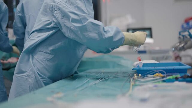 Side view of doctor cleaning vascular stent from blood at French hospital.