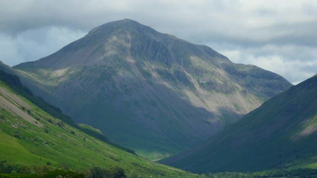 Shadows racing across mountain Great Gable and hilly countryside as thick cloud skims mountaintop. Timelapse 30x. Wasdale, English Lake District, UK