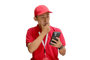 A pensive Asian delivery man or courier in a thoughtful gesture, contemplating something while holding a phone. Isolated on a white background