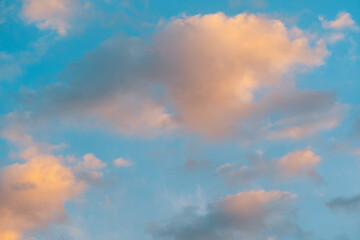 Beautiful orange colored romantic clouds on blue sky at sunset background