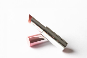 Pink lipstick in metallic tube at white isolated background, cosmetic beauty lips make up