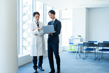 医師と打ち合わせするビジネスマン