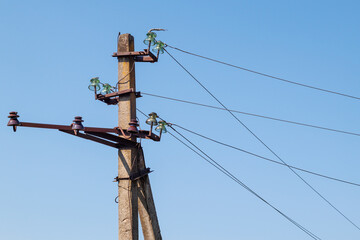 Power lines on the background of the blue sky close-up. Electric hub on a pole. High voltage wires in the sky. Emergency lights out. Destruction of the energy system of Ukraine
