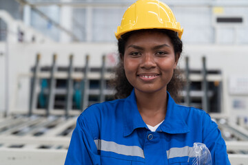 Portrait of female worker working in line production. African American worker at work in industry...