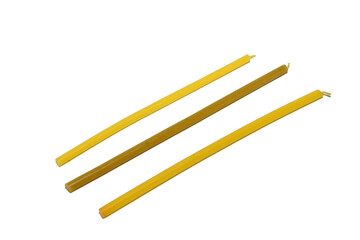 Three wax candles used in church lie on a white background.