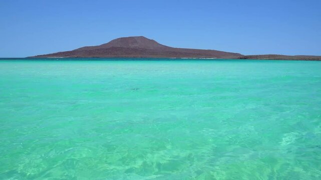 Beautiful turquoise water crystal clear with volcano in the background, Isla Coronado, Loreto, BCS, Mexico