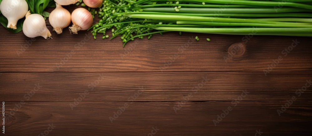Aufkleber Top view flat lay showcasing fresh green onions and garlic on a wooden surface with available copy space image.