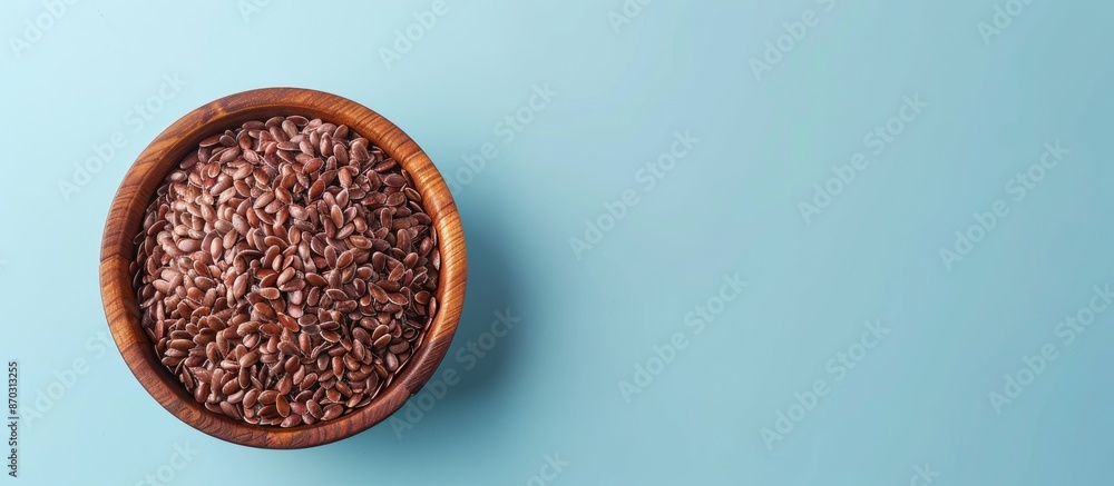 Poster brown flax seeds in wooden bowl isolated on pastel background. with copy space image. place for addi