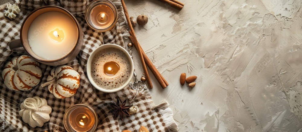 Poster top-down view of an autumn-themed composition featuring a cocoa mug, candles, nuts, and cinnamon on 