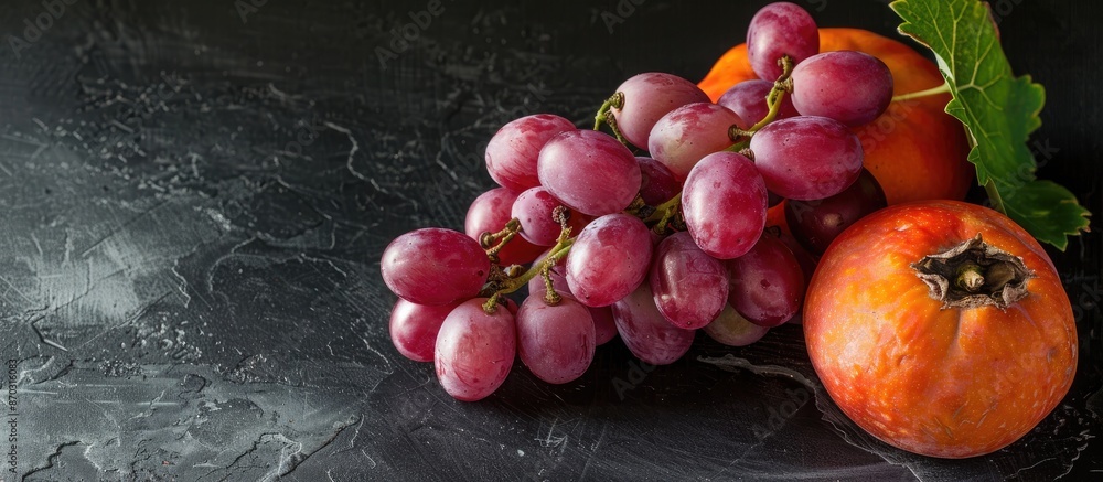 Aufkleber ripe pink grapes and a persimmon isolated on black background with copy space image.