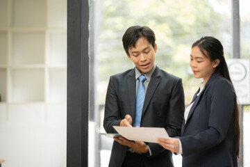 Group of Asian business people planning a project, discussing work documents.