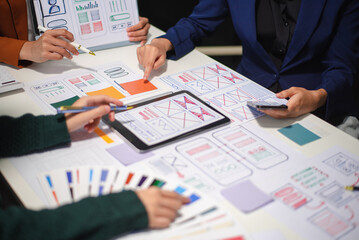 Close up view of UI developer team brainstorming on their project with laptop, smartphone and digital tablet.