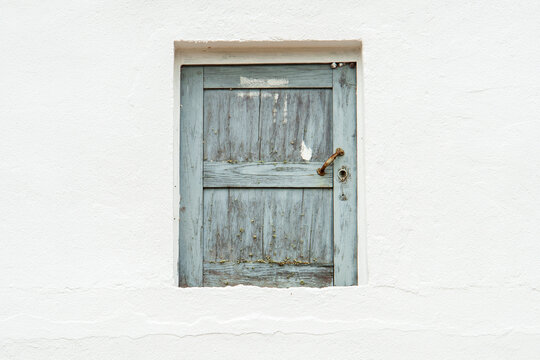 Puerta de madera celeste en pared blanca