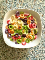 Multi-colored delicious corn flakes with milk. Breakfast of colored corn flakes