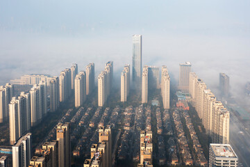 Fototapeta premium Aerial view of the city in the fog. Skyscrapers above the fog