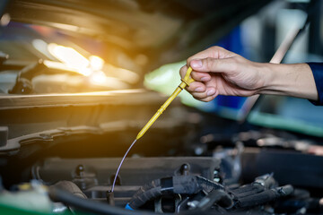 A Car mechanic changing engine oil Pouring new engine oil into the engine Changing car engine oil in the garage Change parts Check the distance of the car Inspection and maintenance