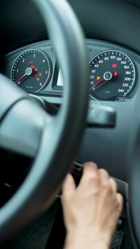 Close-up of a woman hand inserting the car keys into the car socket and starts the engine