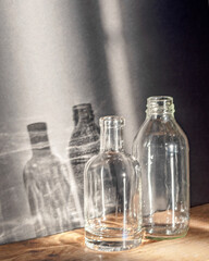 Still life with glass bottles, quiet shadows in the background, soft evening light